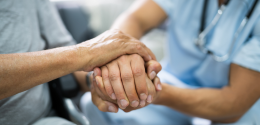 Hands comforting hospice patient by touch massage