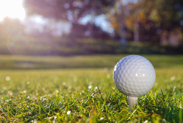 golf ball on tee in grass