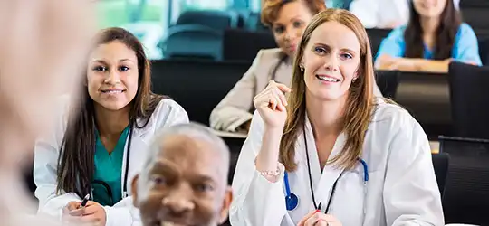 female doctor taking a class with other providers